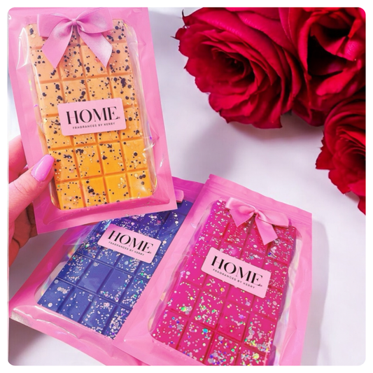 Packaged home-themed products with colorful packaging and pink ribbons, surrounded by red roses on a white background.